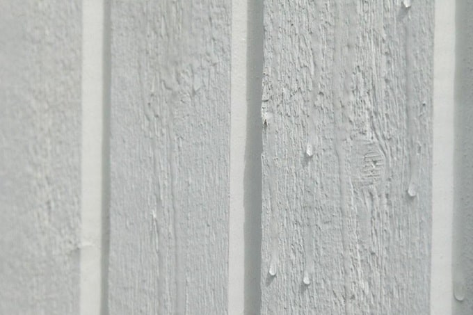 Водоэмульсионная латексная краска на деревянной поверхности.
